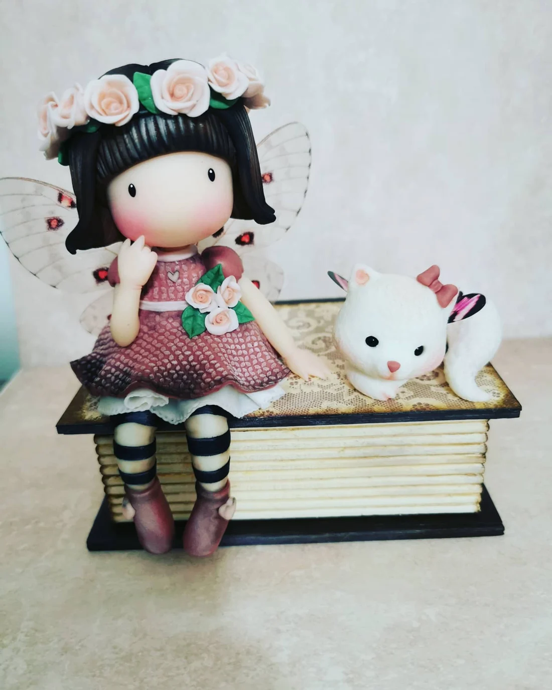 Bonequinha artesanal com flores, livros e uma chávena de chá